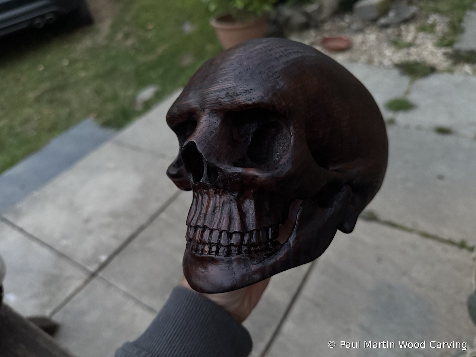 Dark carved wooden human skull